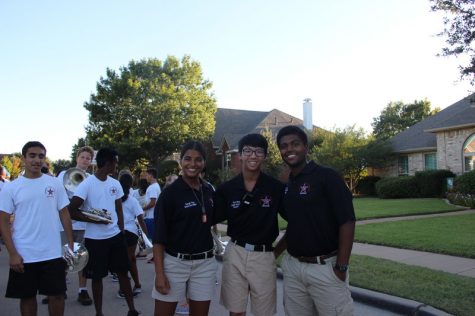 Coppell High School drum majors Ashna Pathan (junior), senior Sam Wang and senior Rishav Rout stand at the head of the band to prepare to lead it in the homecoming parade on Wednesday afternoon. They will backwards march to face and conduct the band during the route. Photo by Hannah Tucker.