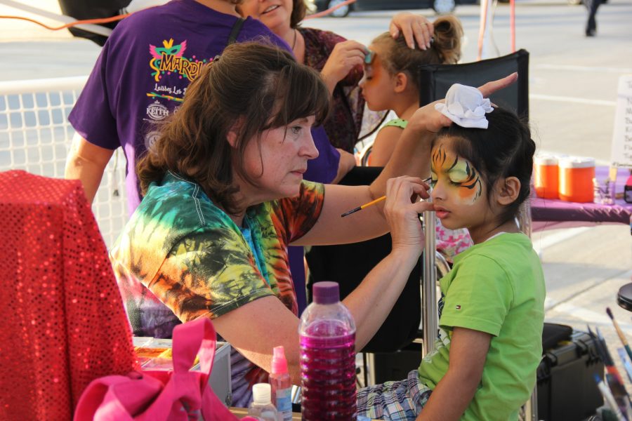 Young children’s faces are painted to resemble colorful animals near the arts and crafts stations. This Saturday, Coppell partnered with Dodie’s to hold its first annual Mardi Gras in the Fall event at the Square in Old Town Coppell.