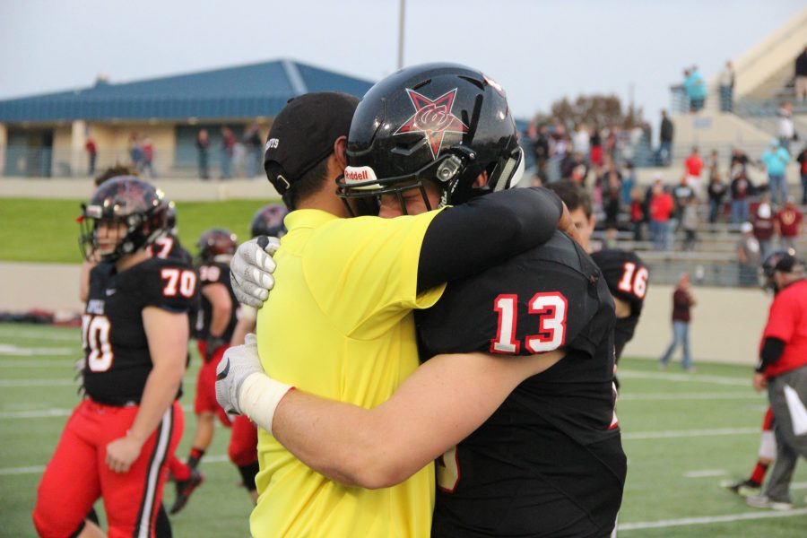 Coppell High School senior Ryan Jones shares a hug with assistant football coach Eric De Los Santos after the end of todays game at WISD Stadium. The Coppell Cowboys fell to the Round Rock Dragons with a final score of 49-45 in the regional semifinals.