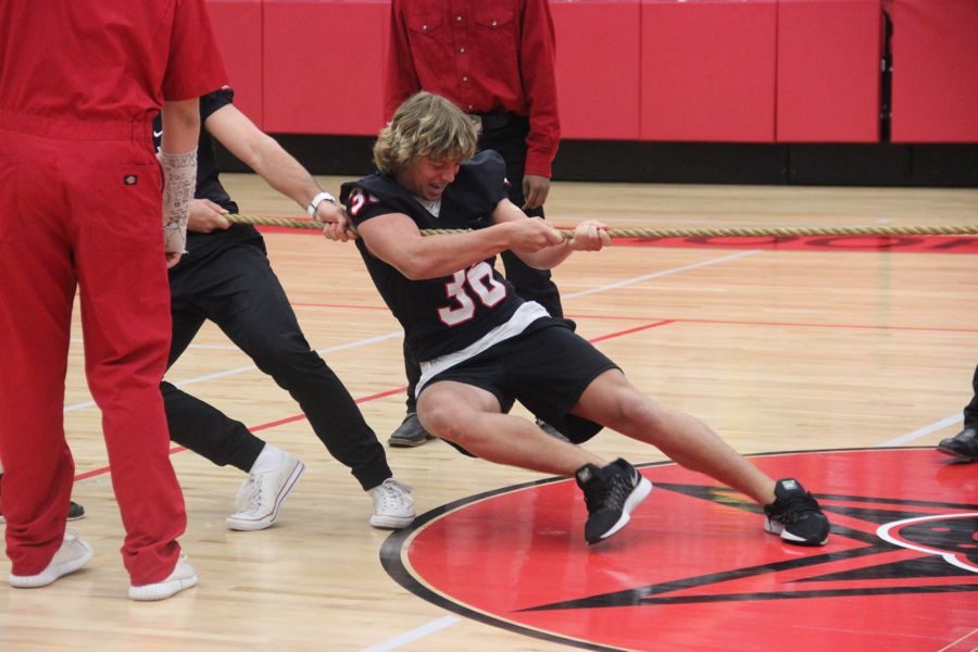 Coppell High School senior football player Skyler Siedman participates in the tug a war event held by the silver spurs during the pep rally on Oct. 28. The senior girls beat the football players in the game in the CHS arena. 