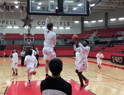 Senior guard Caeden Horak warms up with senior guard Christian Plummer before the game against McKinney Boyd on Tuesday at the CHS arena. The Cowboys won the game 64-54.