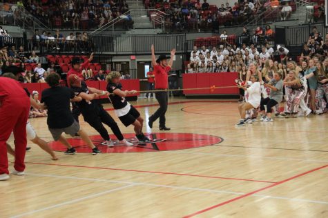 Coppell High School senior varsity football players compete against the senior varsity girls’ volleyball players in a game of tug-of-war in the pep rally on Friday in the arena. Proving their strength, the girls quickly won by a majority. Photo by Hannah Tucker.