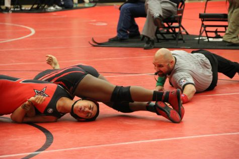 Coppell High School senior Alianna Laione gets pinned down by opponent from Liberty High School last Friday in the Coppell Arena. With a solid performance, the Coppell Cowboys girl's wrestling team places top three in multiple weight categories.