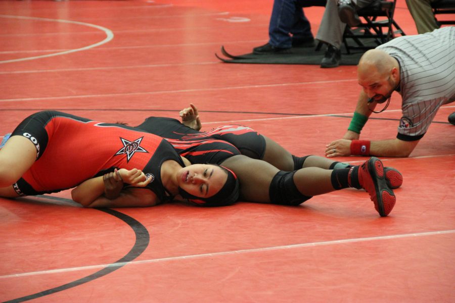 Coppell High School senior Alianna Laione gets pinned down by opponent from Liberty High School last Friday in the Coppell Arena. With a solid performance, the Coppell Cowboys girls wrestling team places top three in multiple weight categories.