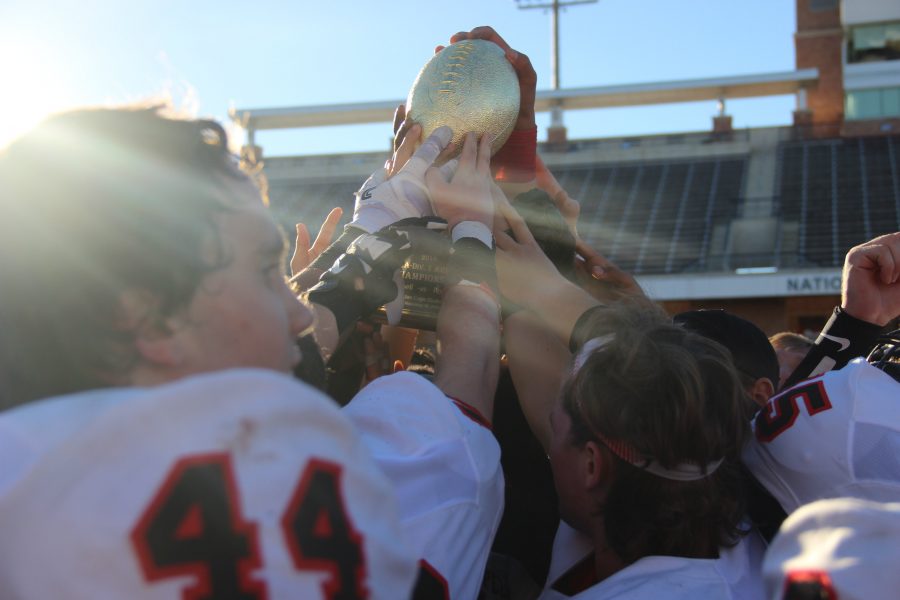 The Coppell football team holds up the area trophy following the Cowboys 29-25 victory over Rockwall. It was Coppells deepest playoff run in six years.