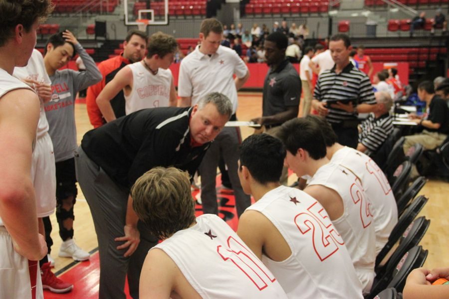 Coppell coach Kit Pehl talkins with his team during a timeout during the game on Tuesday. After a close game, the Mustangs claimed a victory over the Cowboys with a final score of 55-45.