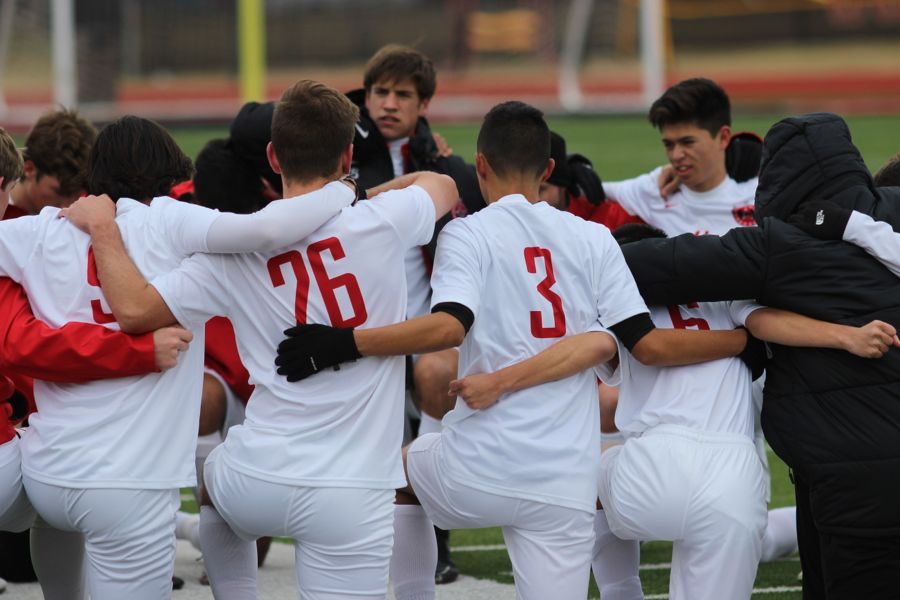 The Cowboys soccer team kneels to pray before the game at Buddy Echols Field on Jan. 5. The Cowboys defeated Lewisville, 2-1, to start the season with a win. 