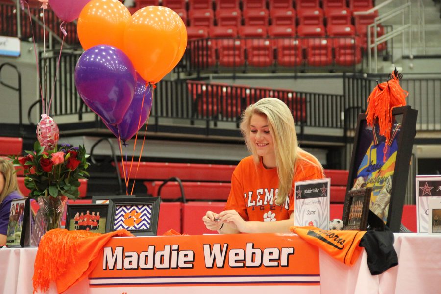 Coppell+High+School+senior+Maddie+Weber+cheers+on+another+signee+as+they+sign+their+letter+of+intent+a+on+Monday+morning.+Weber+signed+on+with+Clemson+University+to+continue+her+soccer+career.+In+the+CHS+arena%2C+12+CHS+seniors+welcomed+their+friends+and+family+to+join+them+for+National+Signing+Day.