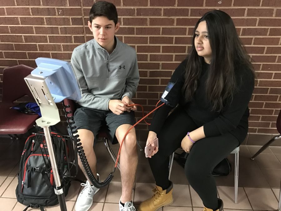 Coppell High School sophomore Carson Samples practices taking senior Inaara Haras’ blood pressure on Friday. The blood drive was held in the CHS small gym and is a great way to help others in need. 