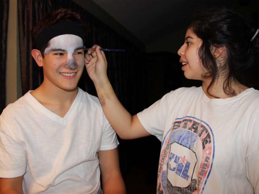 Coppell High School junior Jasmine Diaz paints on senior Brandon Medel’s face on Tuesday night at her house. Diaz is part of the CHS art program, and is creating her Visual Arts Scholastic Event (VASE) project.