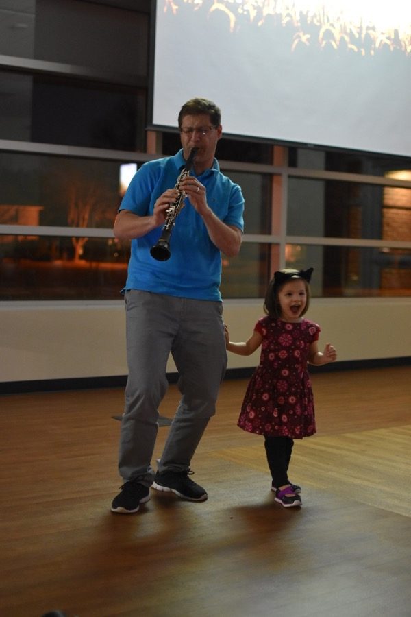 Coppell resident Nicolas Garcia plays a jazz song on the clarinet while his daughter dances yesterday night at the Coppell Library. The Library will be hosting open mic nights  the second Wednesday of every month.
