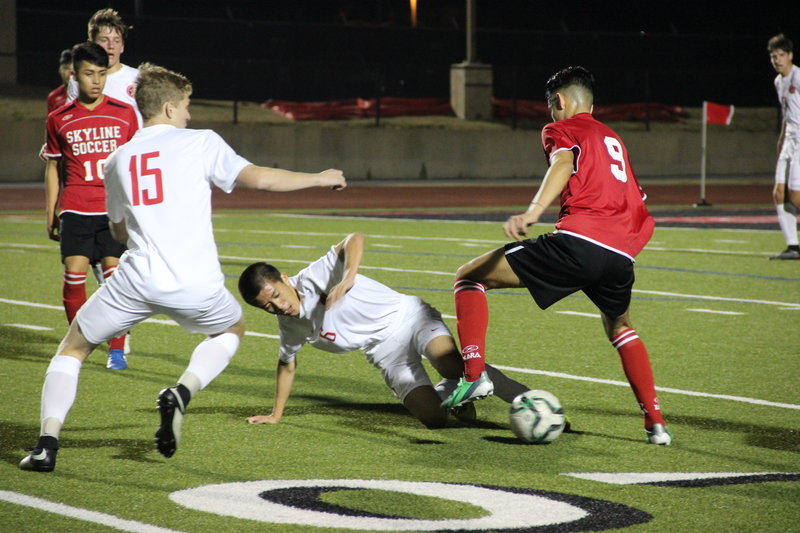 Coppell High School junior middlefield and forward Bryon Peng kicks the ball from Skyline player and tries to pass it to Coppell High School junior defender Jacob Turman  at the Buddy Echol’s field on Friday night. The Coppell Cowboys boy’s varsity won the game with 5-1 score. Photo by Hannah Tucker.