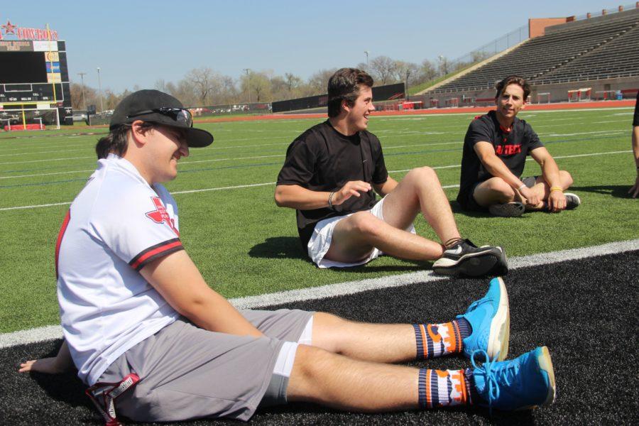 Coppell High School sophomore Christopher Jackson and seniors Davis Green and Mason Holt hang out outside on Buddy Echols Field during fourth period on Wednesday. Jackson is the team manager for the varsity baseball team.