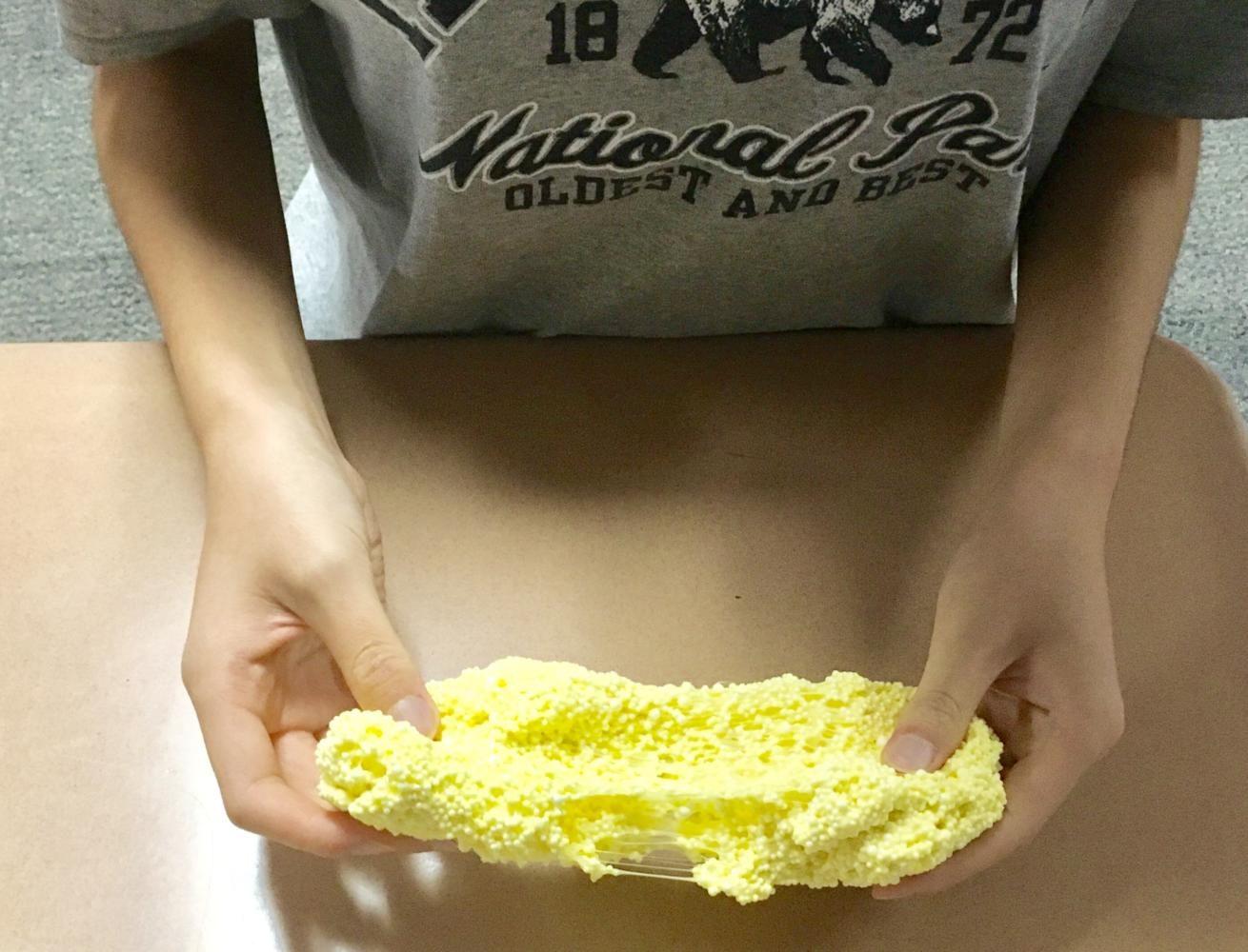 Coppell High School junior Vivian Chen stretches her handmade yellow slime. Chen has a popular Instagram account @slimeybeans where she posts soothing videos of slime to help people relax.