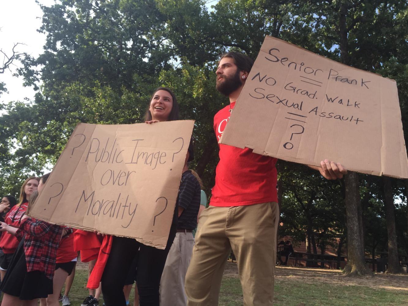 Coppell High School 2013 graduate Josh Escobar and and 2015 graduate Yvette Reyes protest the decision on the sexual assault case out from of the school Wednesday morning. Students and parents gathered out front of the school to show their support for the anti-bullying cause. Photo by Hannah Tucker.