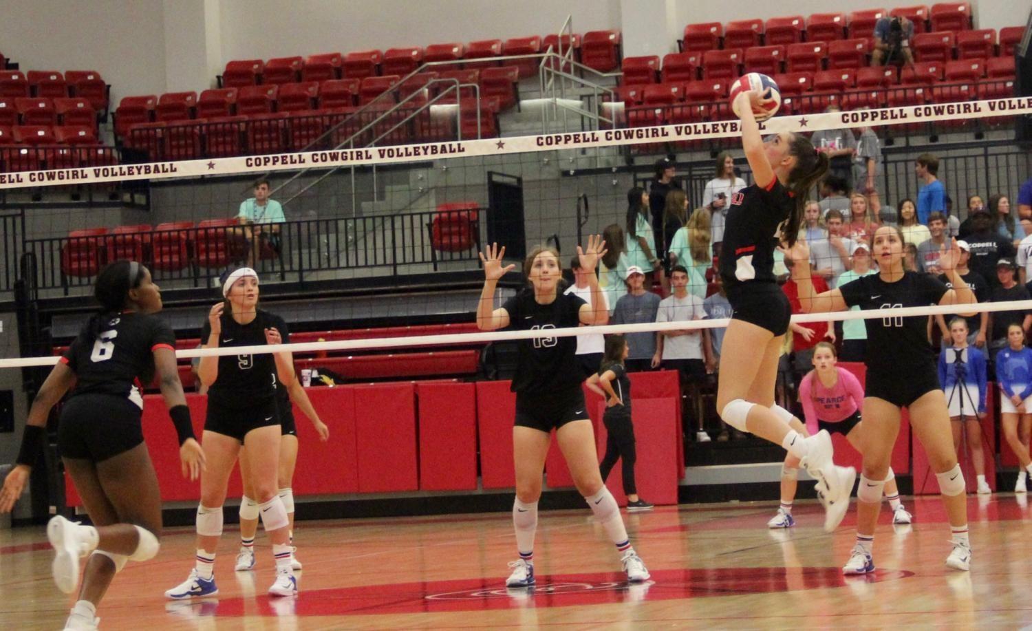 Coppell High School senior defensive specialist Ava Racz sets to junior Amarachi Osuji during last night’s match at the Coppell High School Arena against Pearce on Tuesday night. The Cowgirls defeated the Lady Mustangs, 25-21, 25-23, 24-26, 25-14, in their first home district game.