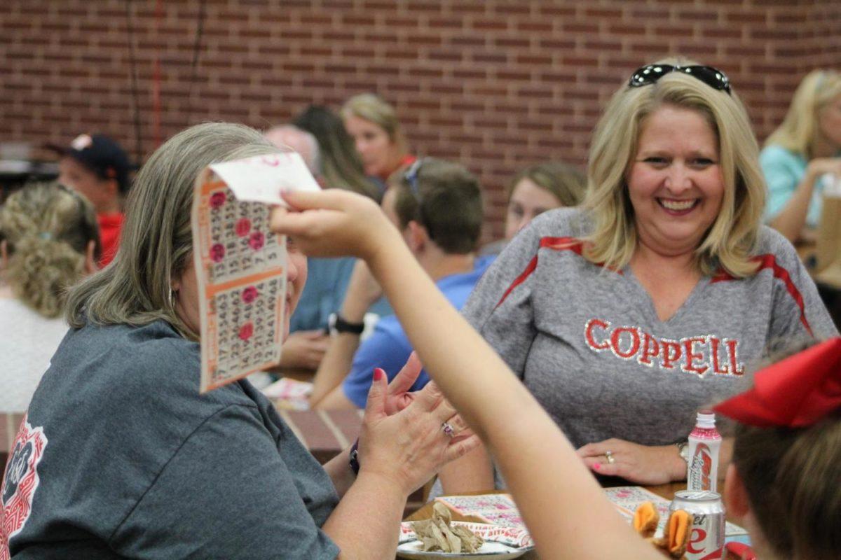 Cheer Bingo’s round three winner Lisa Pehl celebrates winning the round with her friends and family on Friday night at Coppell High School during the cheerleaders annual bingo fundraiser. The event has been held for more than 20 years and helps raise funds for the cheerleading
program.
