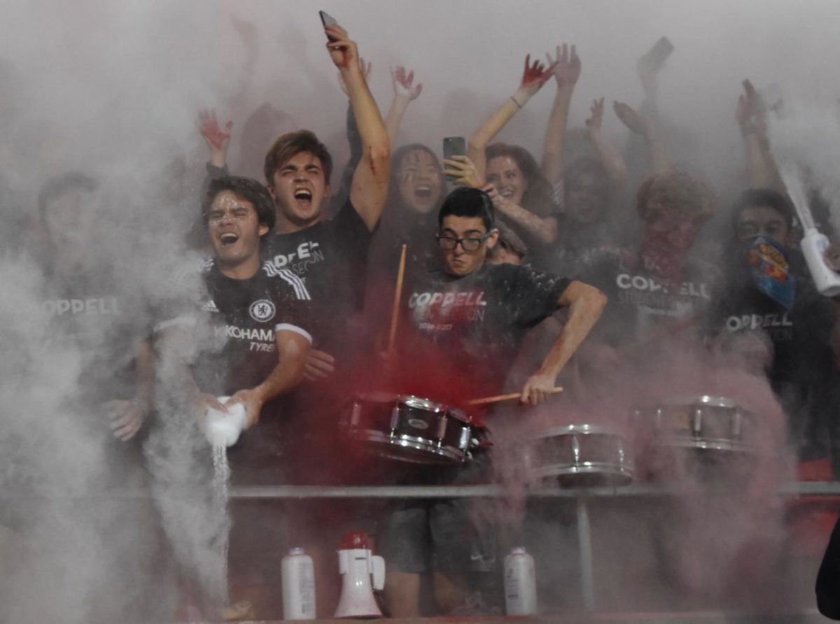 The Coppell student section throws powder as they chant “I believe that we will win” before Friday night’s game at Buddy Echols Field. The Cowboys defeated the Jesuit Rangers, 63-41, for their third win of the season. 