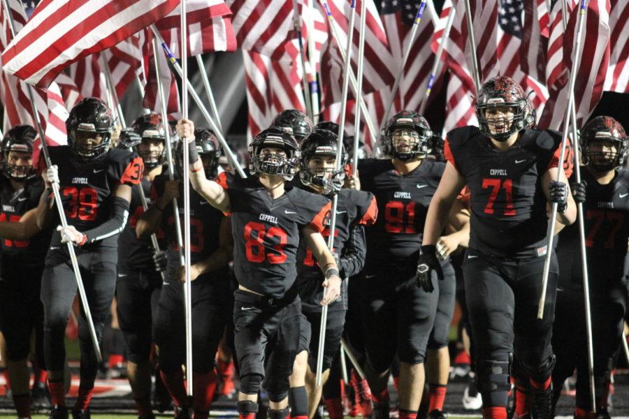 The+Coppell+Cowboys+march+out+with+American+Flags+before+the+game+on+Nov.+10+at+Buddy+Echols+Field.+The+Cowboys+commemorate+the+men+and+women+that+dedicate+their+lives+to+the+United+States+for+Veterans+Day.