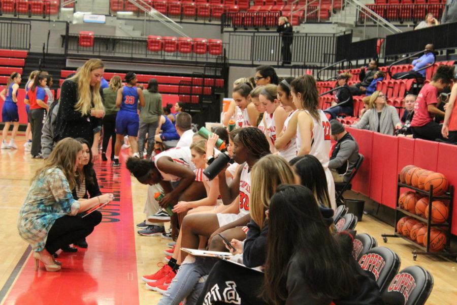 Coppell High School girls basketball players group up to discuss their strategy with coach Kristen Davis last night in the arena as they are scoring higher than the visitors at the end of the first match. The Coppell Cowgirls defeated the Lady Mustangs girls basketball team 45-36.
