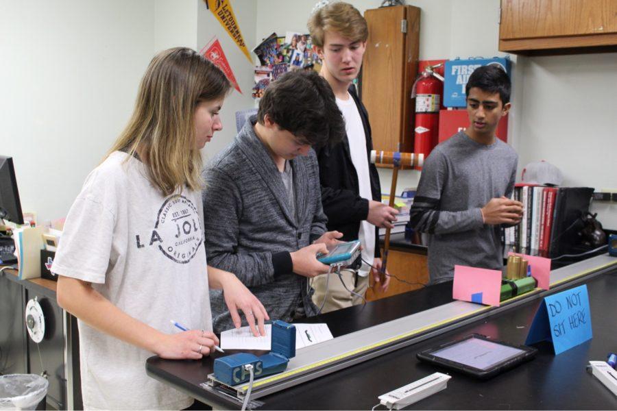 Coppell High School juniors Elizaveta Pchelko, John Caples, yash Sharma and Ruen Mikaelyan do an impulse and recoil activity in Stephanie Sloanes GT/AP Physics I sixth period class on Tuesday. In this activity, learners use cars to measure the velocities of two cars as they run towards each other.