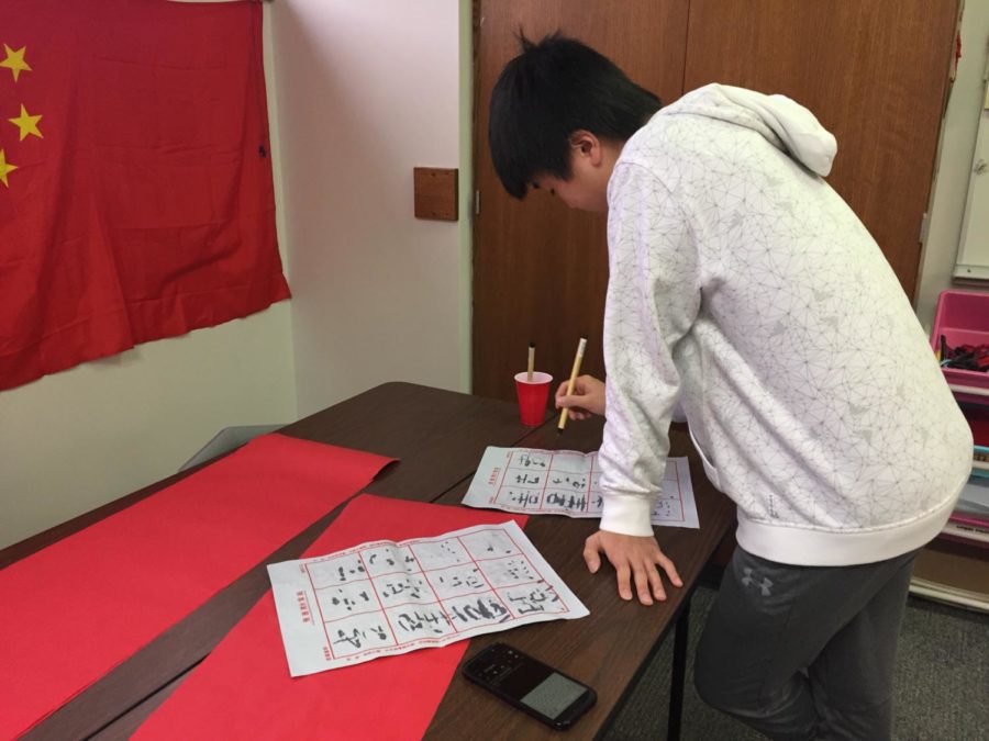 CHS Freshman Alex Tan practices his chinese calligraphy during second period with a reusable paper that requires using water. Students got to choose what type of paper they want to practice their calligraphy on.