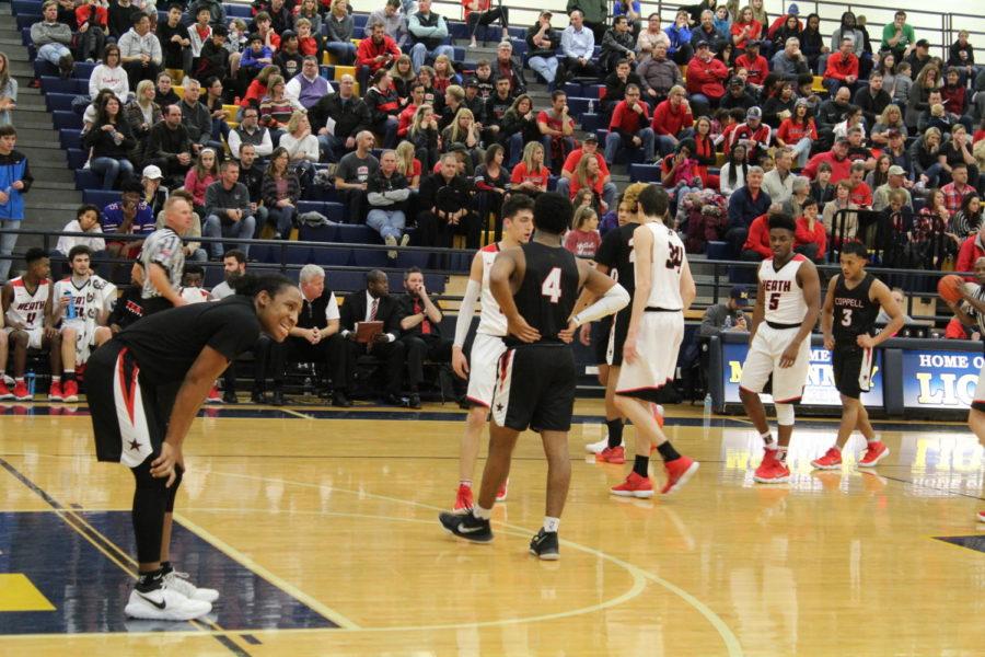 Coppell senior guard Jaylon Wilson and his teammates show their disappointment following Friday night’s playoff game loss against Rockwall-Heath at Mckinney High School. The Cowboys fell short to Rockwall-Heath to end their season with a score of 63-34. Photo by Varsha Kanneganti