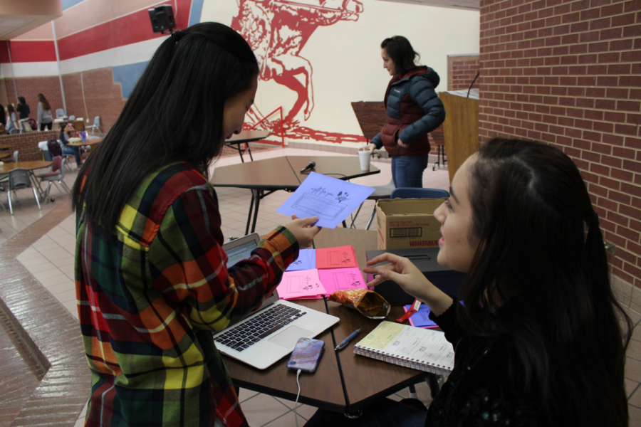 Coppell High School senior Student Council officer Ashley Benyahoun sells carnation grams to senior Sol Hong on Thursday during lunch in the commons. The CHS Student Council is holding a Valentine’s Day Carnations fundraiser where students buy and request carnations to be sent to their friends or teachers. Carnations costs $1 each and are sold during all lunches in the cafeteria through Friday.  