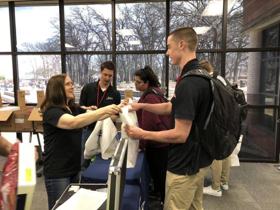 Coppell High School senior Hayden Lawrence picks up his cap and gown in the library classroom. Jostens will be at the high school until 5 p.m. so that seniors can pick up their graduation orders. 