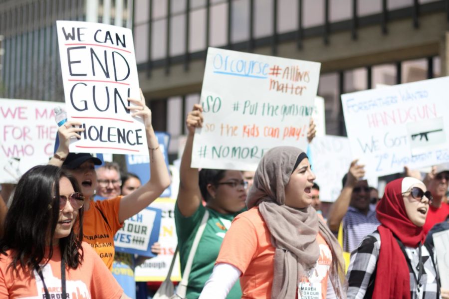 Marching protesters lift their signs and lead chants in support of gun control. On Saturday, protesters gathered to speak out against gun violence in the March For Our Lives in Dallas.