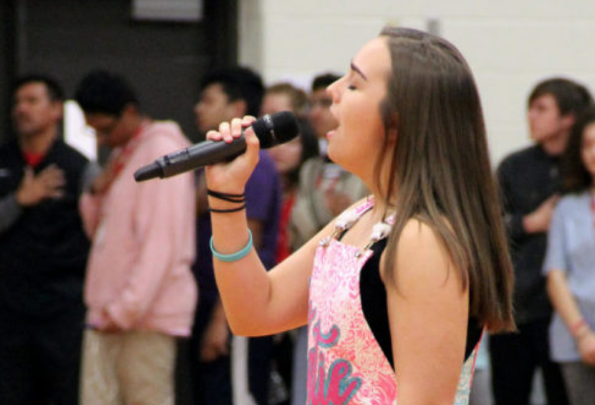 Coppell High School senior Katie Love sings the national anthem at a pep rally. Love is among the students looking to auditioning for an opportunity to sing at graduation and the Senior Awards.