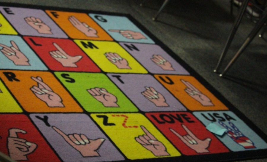 The alphabet and the phrases “love” and “USA” in American Sign Language (ASL) are displayed on a carpet in CHS ASL teacher Delosha Payne’s classroom. The ASL alphabet is the basis of the language.