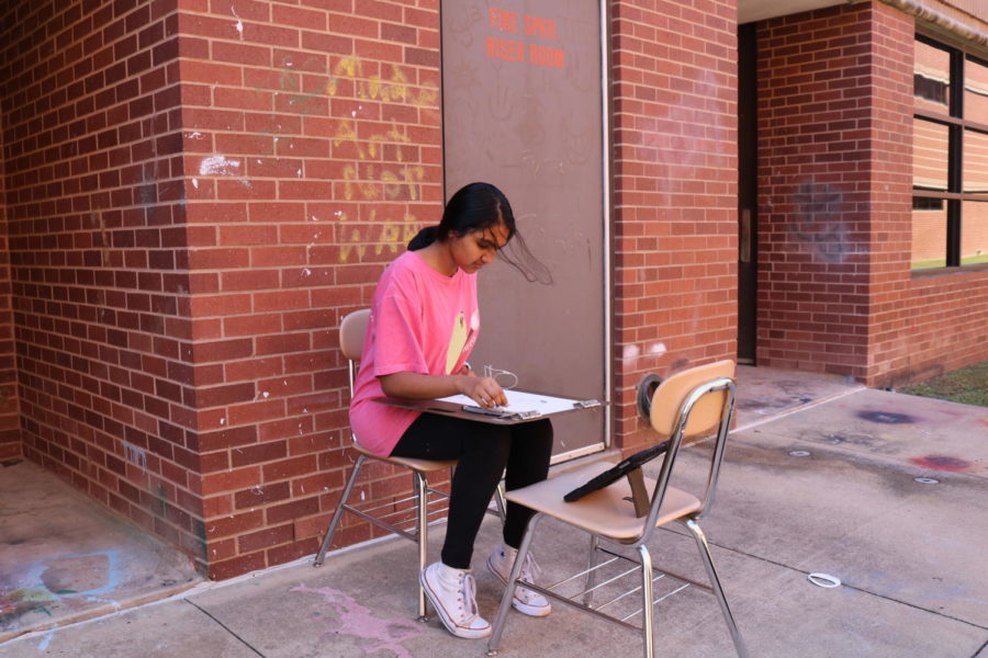Coppell High School junior Varsha Chintapenta works on drawing images from her phone in Michelle Hauske’s AP Drawing class. This class involves developing different skills such as drawing and creativity. 