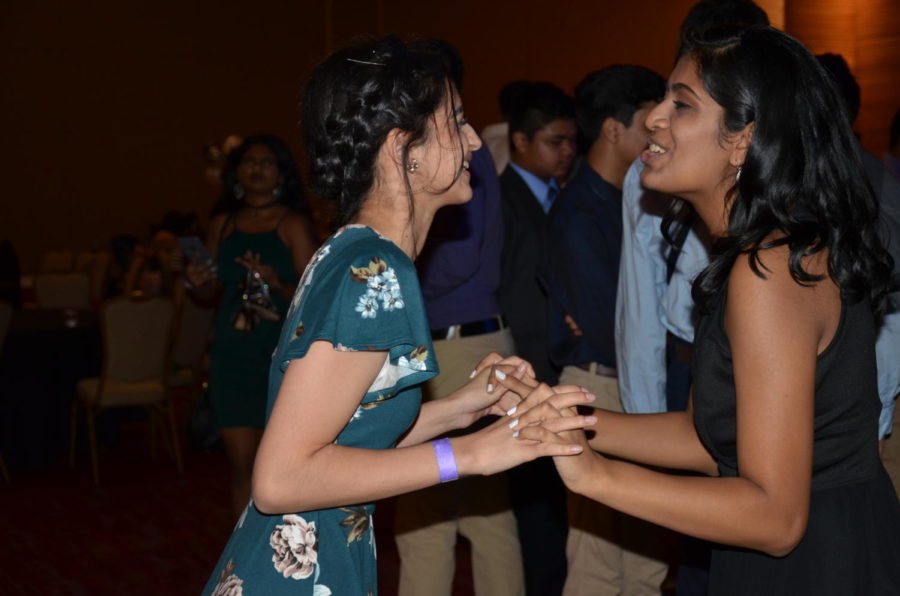 Coppell juniors Amsah Rauf and Mansi Patel sing and dance together at Coppell High School’s annual homecoming dance on Saturday night at Irving Convention Center. In the week leading up to the dance, there are numerous traditions in CHS, including spirit week and mums and garters.
