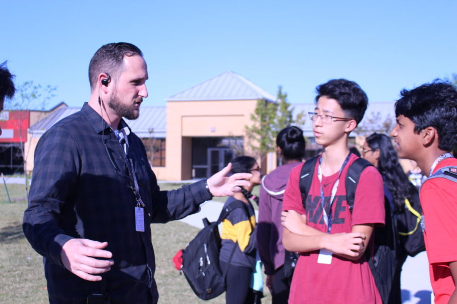 CHS9 assistant principal Chase Vaughn visits with freshmen Sam Ko and Pranav Swarna while on bus duty after school on Oct. 26. Vaughn has returned to Coppell ISD, and has worked at Coppell Middle School North in 2008 and Coppell High School in 2010 as a teacher and coach. 
