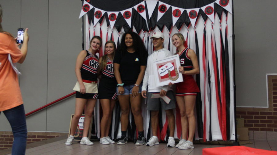 Junior varsities sophomore cheerleaders Katy Kryzak, Taylor Kniff and senior varsity cheerleader Laurie Sanford takes a picture with the winning bingo players on Friday Sept. 23 at Coppell High School. Once you yell bingo and match all the spots you can win a prizes such as gift cards, money, and more.