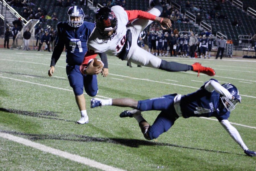 Coppell senior quarterback Taj Gregory dives into the end zone for a touchdown against Irving Nimitz on Nov. 9 at Joy and Ralph Ellis Stadium. The Cowboys defeated the Vikings, 35-14.