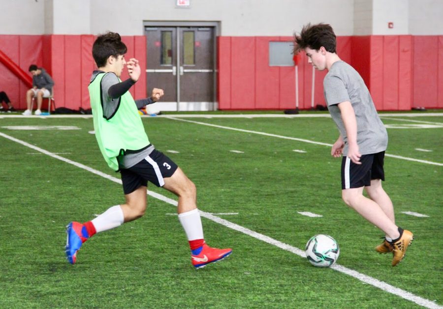 Coppell High School junior Richard Bracho defences the ball against Coppell High School sophomore Oliver Isenberg during practice in the fieldhouse on Nov. 28. Bracho is originally from Venezuela and moved to Kentucky two years ago, and this school year moved to Coppell where he enjoys his passion for soccer. 
