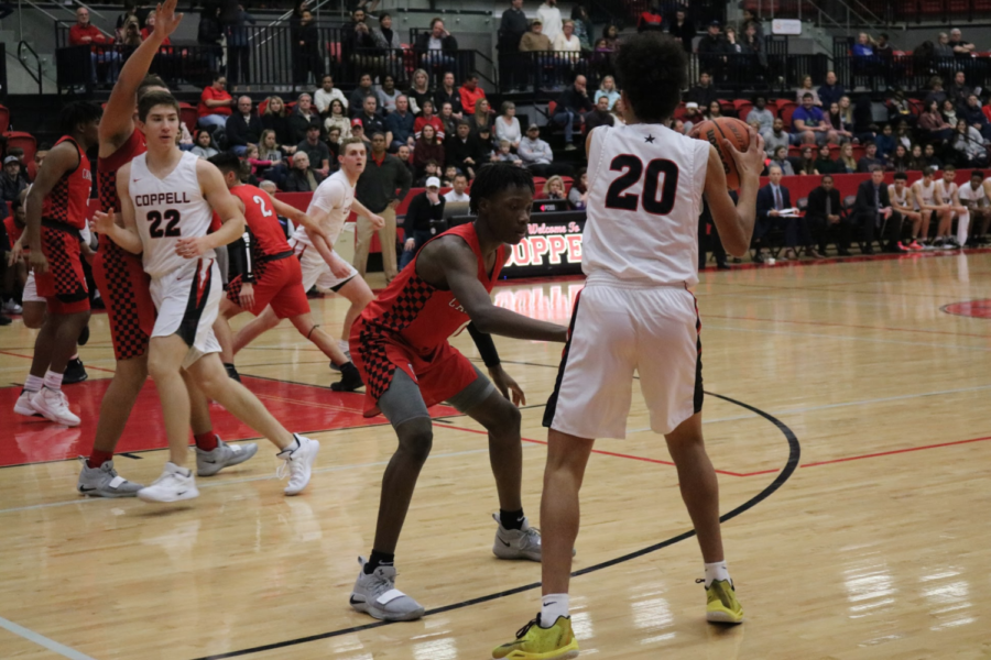 Coppell+High+School+freshman+Anthony+Black+protects+the+ball+from+the+Macarthur+Cardinals.+The+Coppell+varsity+basketball+team+won+56-55+against+the+Macarthur+Cardinals.