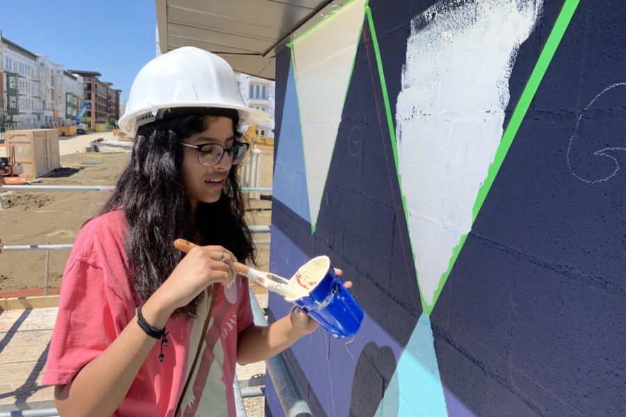 Coppell High School sophomore Ishita Sisodia helps paint a mural at Pump Station in Cypress Waters yesterday. CHS art teacher David Bearden provided students the opportunity to create a mural at Cypress Waters. 