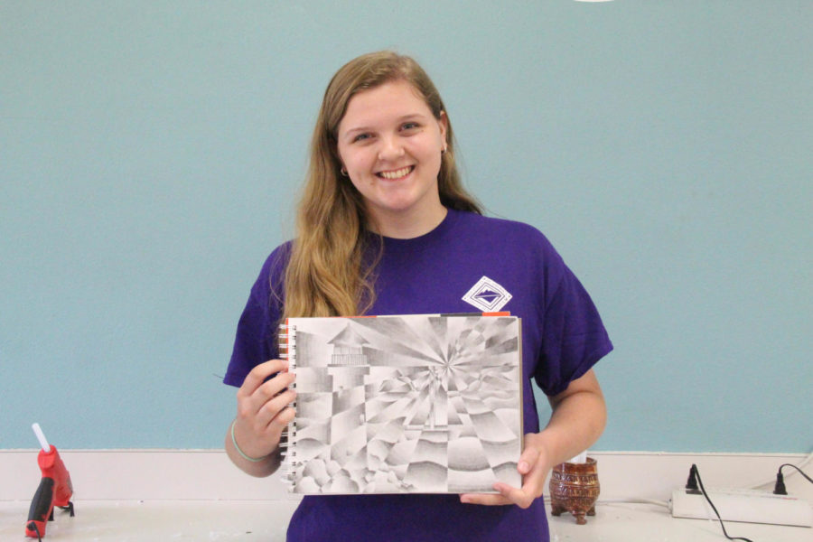 Coppell High School sophomore Jordan Buffington shows of her sketch for David Bearden’s Art 1 honors class. Buffington is painting a mural with professional artist Mary Lacy in Cypress Waters on Sunday.
