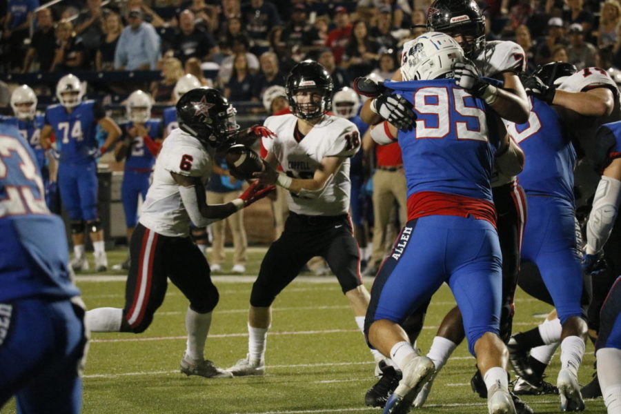 Coppell junior quarterback Ryan Walker hands off to junior running back Jason Ngwu as they near the endzone at Eagle Stadium on Friday night. The Cowboys kept up with Allen but eventually fell, 28-21, to the nationally-ranked team.