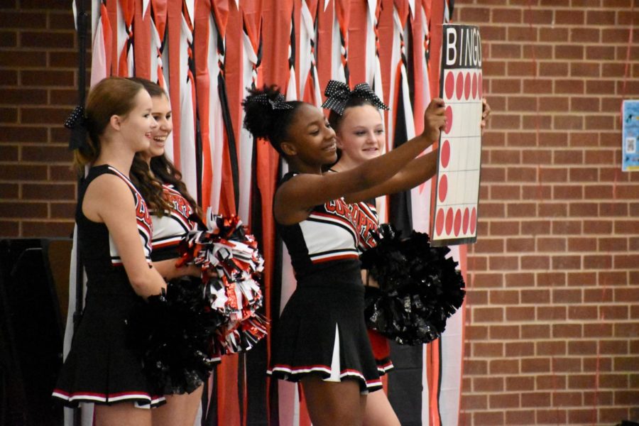 Coppell High School juniors Melanie Miller, Madeline Whitfield, sophomore DeAni Payne and freshman Claire Cowart-Watkins hold up a bingo card during the annual cheer bingo on Sept. 20 in the CHS Commons. This year marked the cheer team’s 20th year of bingo night which they host as a fundraiser to support the team.