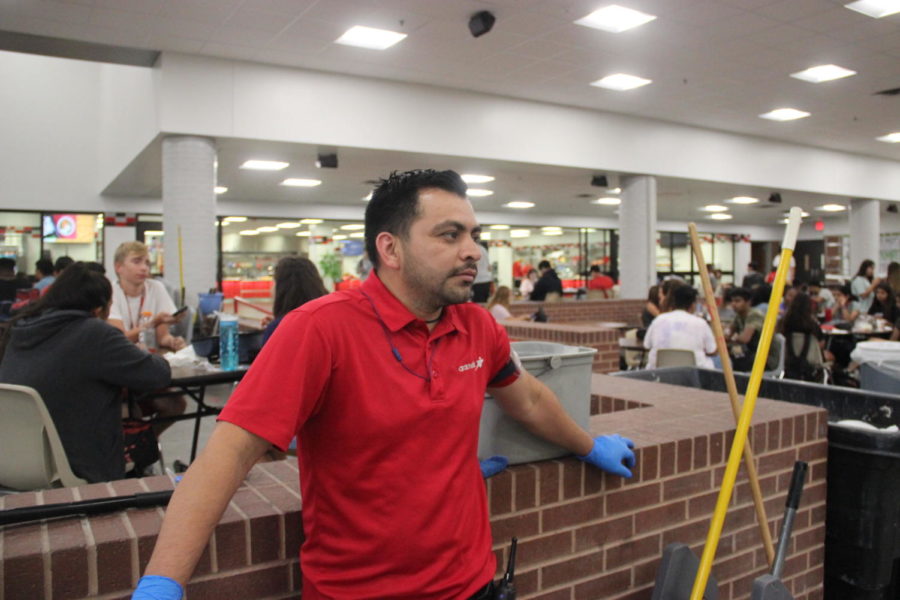 Custodian Rudis Arguata watches the students enjoy their lunch in the Coppell High School cafeteria during C lunch on Aug. 26. Custodians do not have their own office or specific meeting place, so oftentimes they can be found in the communal spaces around the school. 
