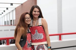Coppell High School seniors Heather Lee and Caroline McConnell get their picture taken on the senior bridge on Friday. Senior girls wore overalls today for the first home football game of the year.