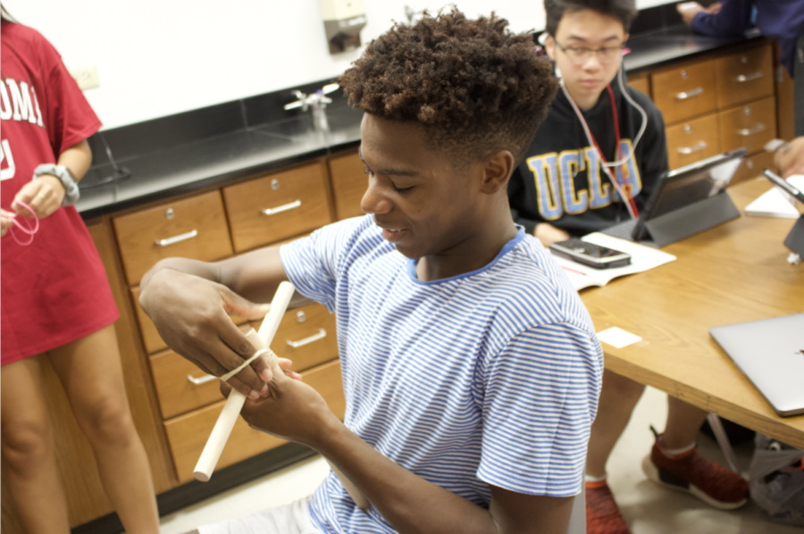 Coppell High School junior Obi Odimegwu puts together the base of his catapult in physics teacher Cynthia Lee’s second period class on Wednesday. Physics students are building catapults to see measurements and equations be put in a real life example.