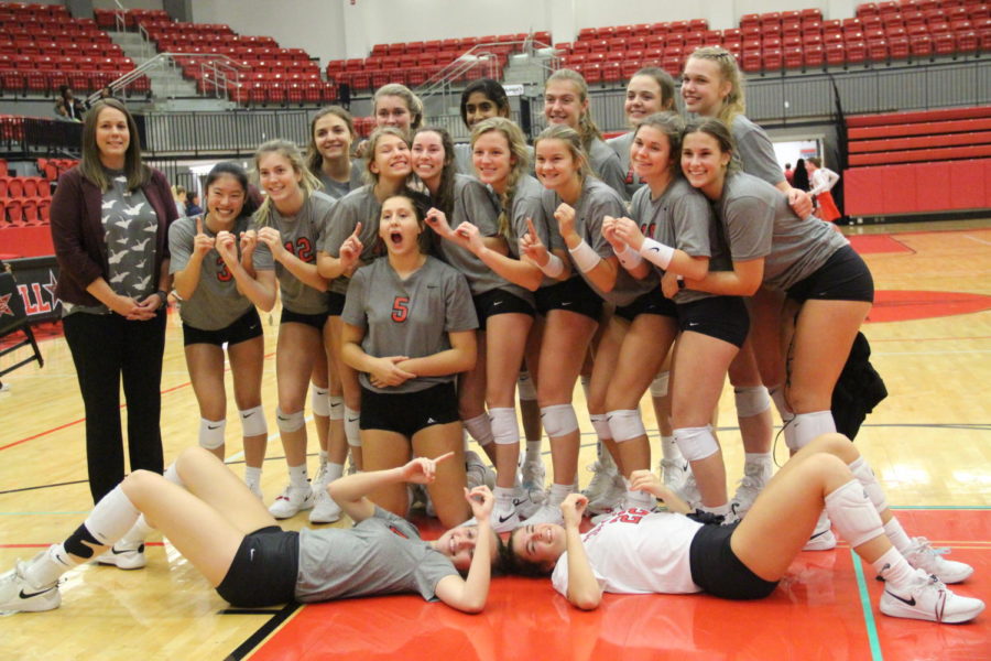 The Coppell volleyball team celebrates Madison Gilland’s one thousandth career win with a group picture in the Coppell High School Arena on Friday. Coppell defeated Lewisville, 3-0. 