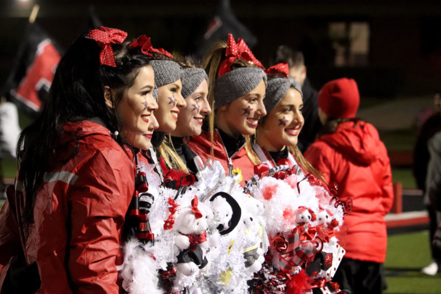Coppell High School cheerleaders pose with their mums at the homecoming game on Friday night at Buddy Echols Field. The Cowboys beat the Tigers, 55-7, in their fifth district game of the season, bringing their district record to 2-3.