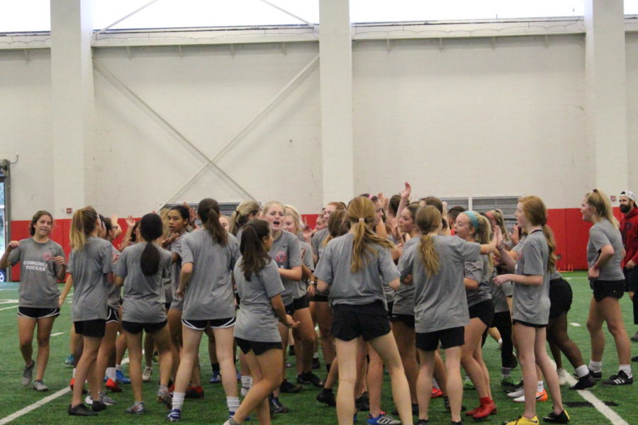 The Coppell girls soccer team high-fives each other after a warm up on Oct. 9 in the Coppell High School Field House. Cowgirls Supporting Cowgirls (CSC) is a group that promotes Coppell women’s sports in order to increase attendance at their games. 