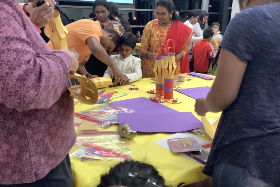 Ranjan Gupta helps his son make a paper lantern at Cozby Library’s Diwali Family Fun Night on Tuesday. Decorating lights is one of the main customs of Diwali. Photo by Sreeja Mudumby